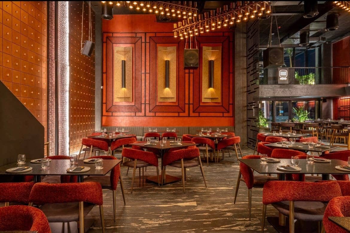Red chairs, set tables and copper panels at Noho