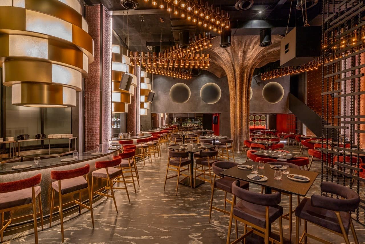 Grand dining hall with bar counter and seating at Noho